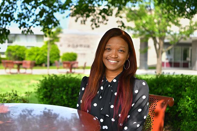 Akedra W. sitting outside on campus